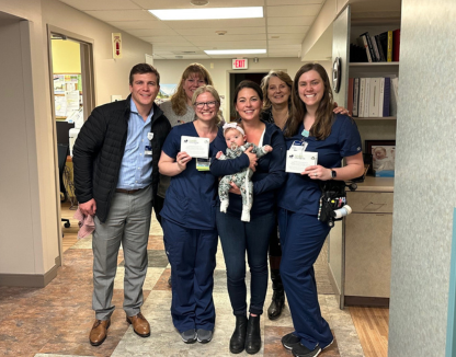 Hospital staff posing with mother and her baby 